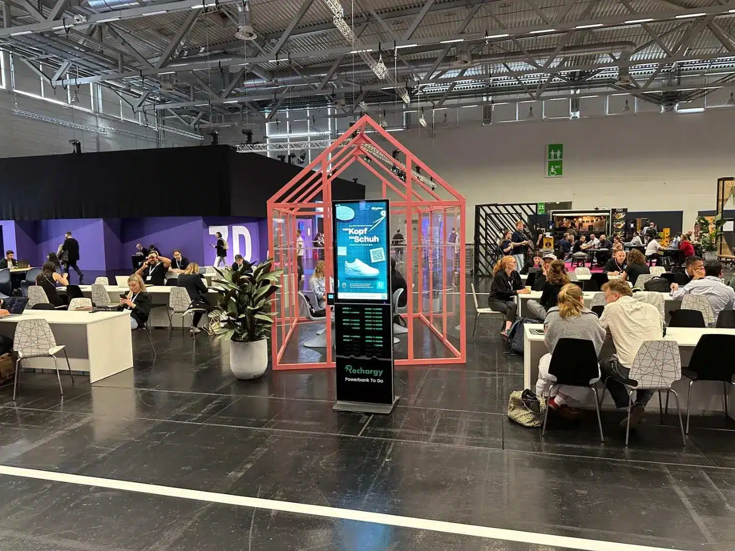 Rechargy Powerbank-Station mit Deichmann Branding in einer Messehalle