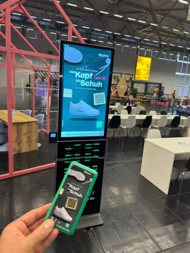 Deichmann gebrandete Powerbank in der Hand vor der Rechargy Station