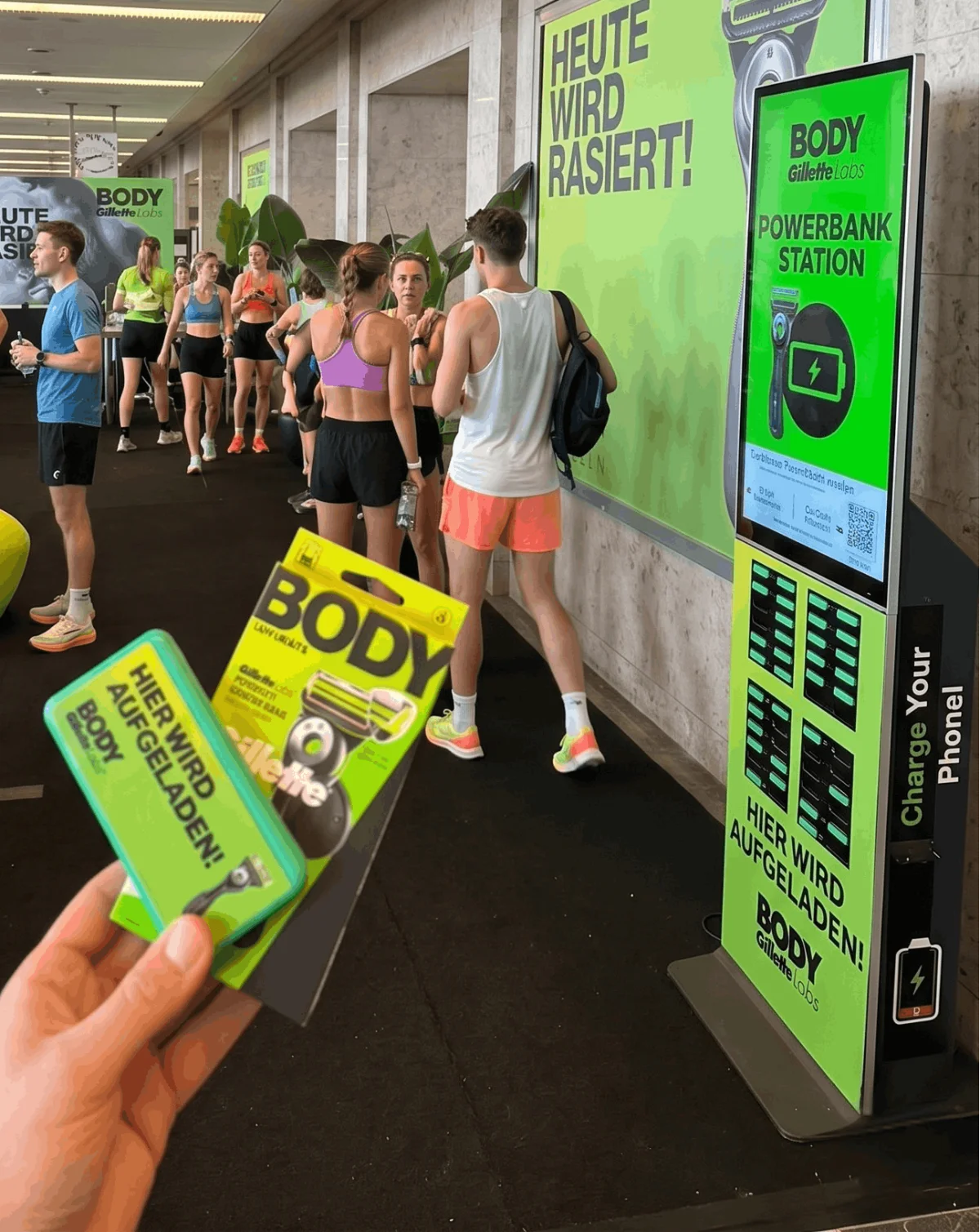 Gillette Labs BODY Powerbanks in der Hand vor der Station