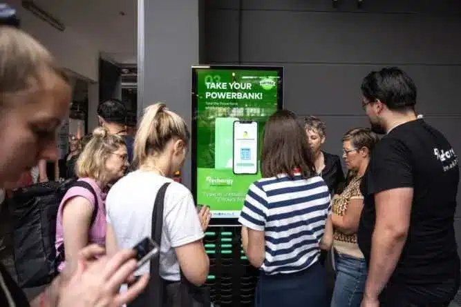 Messebesucher leihen Powerbanks an einer Rechargy Station