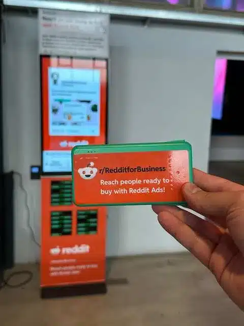 Reddit gebrandete Powerbank in der Hand vor der Rechargy Station
