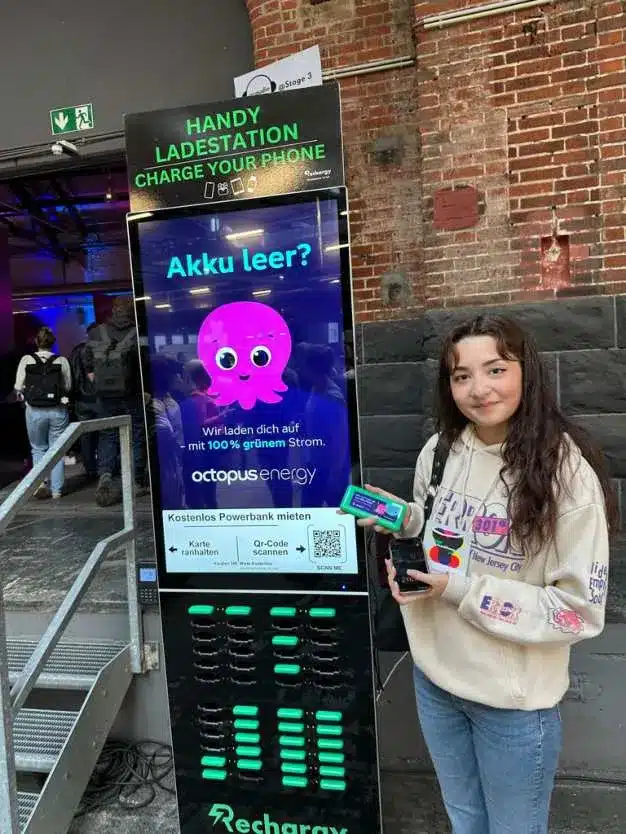 Besucherin an einer Octopus Energy gebrandeten Rechargy Powerbank-Station