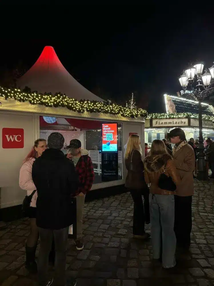 Besucher auf dem Weihnachtsmarkt in Berlin bei Nacht