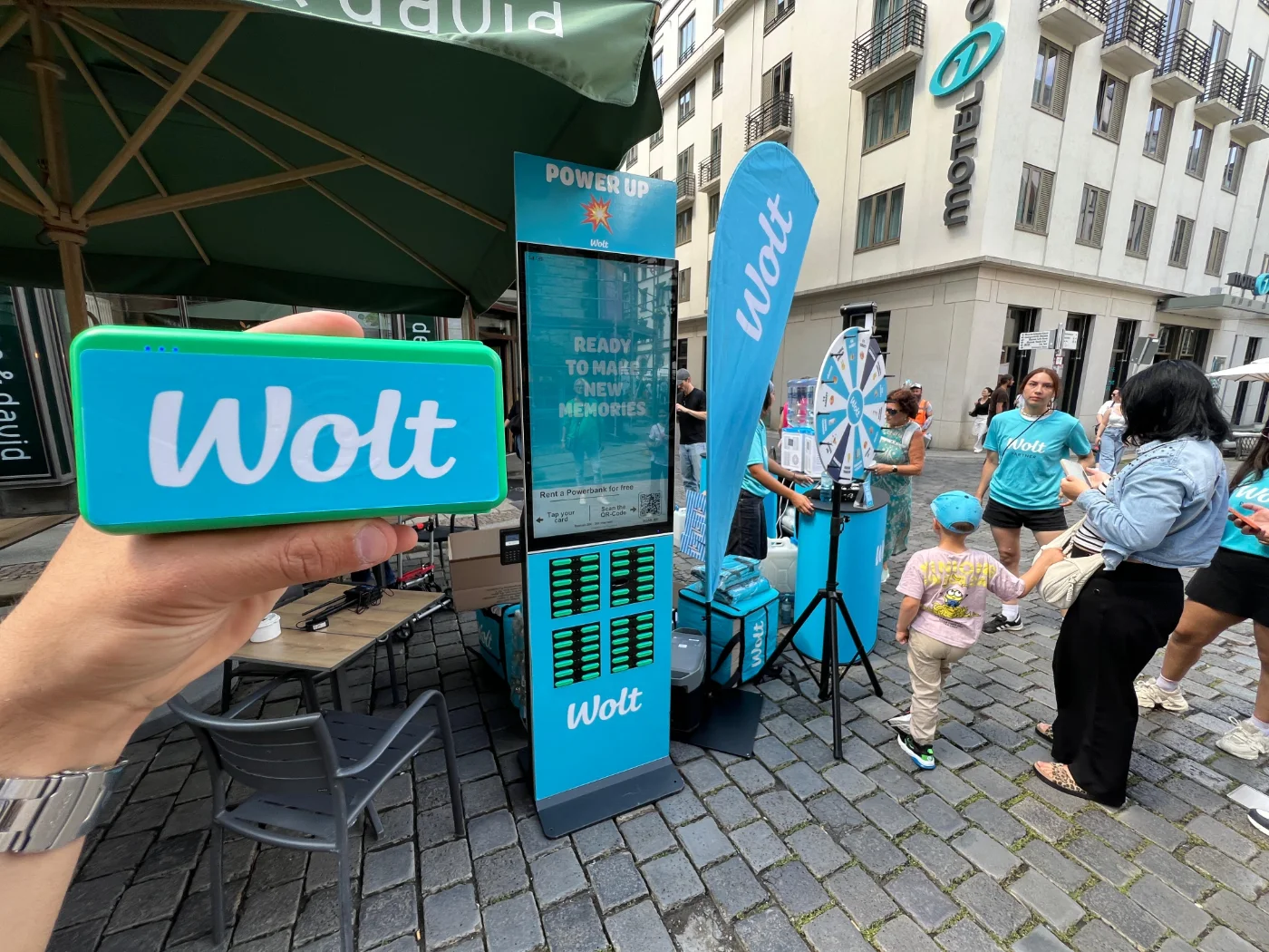Wolt gebrandete Powerbank vor einer Rechargy Station in der Stadt